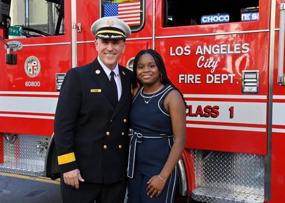 Eniola Taiwo (R) and LAFD Chief Jaime E. Moore participate in an unveiling ceremony honoring the Los Angeles Fire Department with an Award of Excellence star adjacent to the Hollywood Walk of Fame in Los Angeles on Tuesday, December 2, 2025. Taiwo, 14, wrote a letter to the Hollywood Chamber of Commerce suggesting that firefighters who battled the deadly January fires were worthy of a star on the Hollywood Walk of Fame.  LAP2025121226 JIMxRUYMEN
