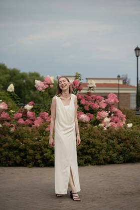 MR_ID31630_22889_AlenaZhdanova.jpg A woman wearing a long white dress stands joyfully in a garden surrounded by vibrant pink and white blossoming flowers, creating a serene and cheerful atmosphere Model Released LiliyaSolopova_ID31630_1075589_002 Copyright: xLiliyaxSolopovax RECORD DATE NOT STATED