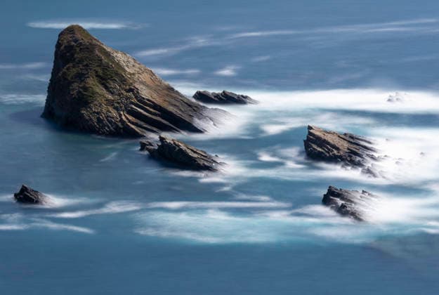Creative Highlights World Rugged rocks on the Playa del Silencio Asturias coastline Serene view of rugged rock formations at Playa del Silencio, Asturias, surrounded by the gentle waves of the Cantabrian Sea under a clear blue sky. Model Released PacoFarero_ID31453_1070032_011 Copyright: xPacoxFarerox RECORD DATE NOT STATED
