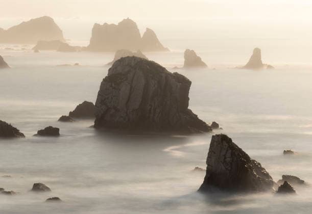 Creative Highlights World Playa del Silencio serene rocky seascape at dawn Misty morning light bathes the rugged rocks of Playa del Silencio, Asturias. The tranquil sea creates a surreal atmosphere along the picturesque Cantabrian Coast. Model Released PacoFarero_ID31453_1070038_016 Copyright: xPacoxFarerox RECORD DATE NOT STATED