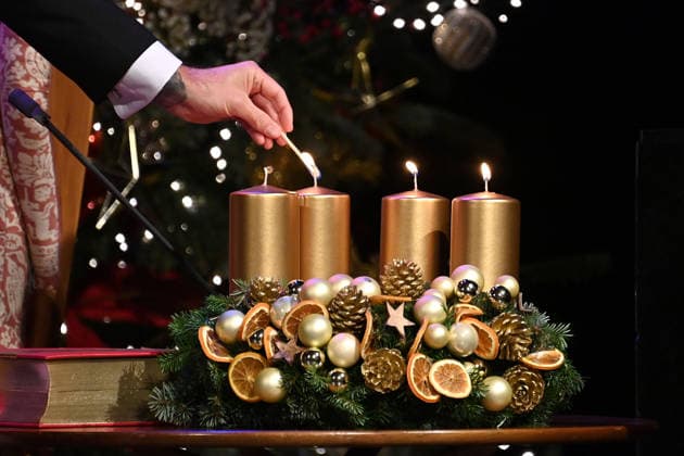 Randmotiv,Anzuenden der Kerzen von einem Adventskranz,Streichholz,Kerze.Kranz. Adventskonzert des Bayerischen Ministerpraesidenten am 15.12.2025 im Cuvillies Theater in der Residenz in Muenchen.