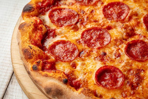 Peperoni-Pizza mit geschmolzenem Käse Hot pepperoni pizza with tomato sauce and melted cheese served on a wooden board (License=RF) Copyright: xZoonar.com MaximxSparishx 24312784