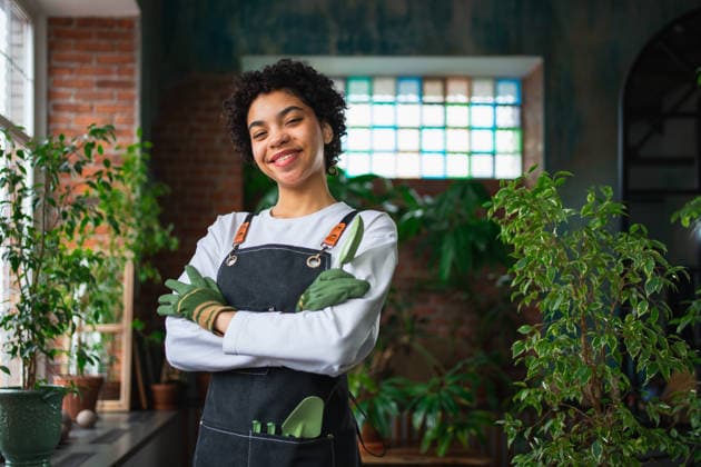 Führen eines eigenen Geschäfts. Afrikanische Frau Florist trägt Schürze in botanischen Laden mit grünen Pflanzen. Glückliche Kleinunternehmerin, die in einem Blumenladen arbeitet und lächelt, umgeben von Pflanzen Kleines Unternehmen. Running of own business. African woman florist wearing apron in botanical store with green plants. Happy small business owner working at flower shop smiling surrounded by plants Small business (License=RF) ,model released, Symbolfoto Copyright: xZoonar.com IuliiaxZavalishinax 24313554 ,model released, Symbolfoto ,property released