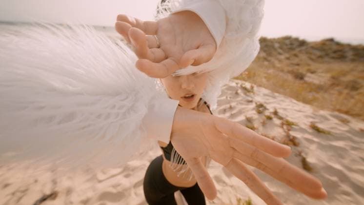 Ein atemberaubender und dramatischer Modemoment am Strand mit fließenden weißen Federn A stunning beach fashion shoot with a model in white feathers striking elegant, artistic poses of vibrancy (License=RF) ,model released, Symbolfoto Copyright: xZoonar.com OleksiixHrecheniukx 24340395 ,model released, Symbolfoto ,property released