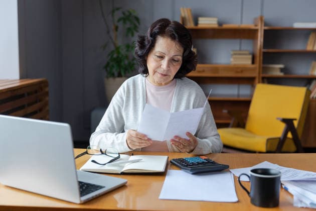 Middle aged senior Frau sitzen mit Laptop und Papier Dokument, Pensive ältere reife Dame Lesen Papier Rechnung zahlen online zu Hause verwalten Bank Finanzen Berechnung Steuern Planung Darlehen Schulden Rente Zahlung Middle aged senior woman sit with laptop and paper document. Pensive older mature lady reading paper bill pay online at home managing bank finances calculating taxes planning loan debt pension payment (License=RF) ,model released, Symbolfoto Copyright: xZoonar.com IuliiaxZavalishinax 24349953 ,model released, Symbolfoto ,property released