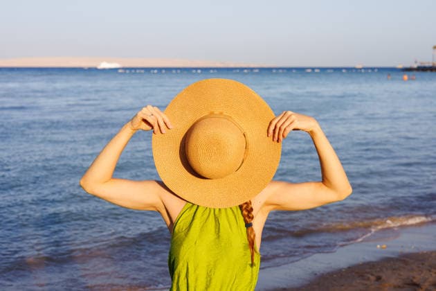Frau hält Strohhut über das Gesicht am sonnigen Strand Woman holding straw hat over face on sunny beach. (License=RF) ,model released, Symbolfoto Copyright: xZoonar.com EvgeniixLashchenovx 24354331 ,model released, Symbolfoto ,property released