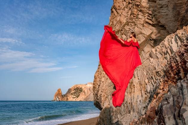 woman sea red dress. Woman with long hair on a sunny seashore in a red flowing dress, back view, silk fabric waving in the wind. Against the backdrop of the blue sky and mountains on the seashore. woman sea red dress. Woman with long hair on a sunny seashore in a red flowing dress, back view, silk fabric waving in the wind. Against the backdrop of the blue sky and mountains on the seashore, model released, , 61526700.jpg RECORD DATE NOT STATED