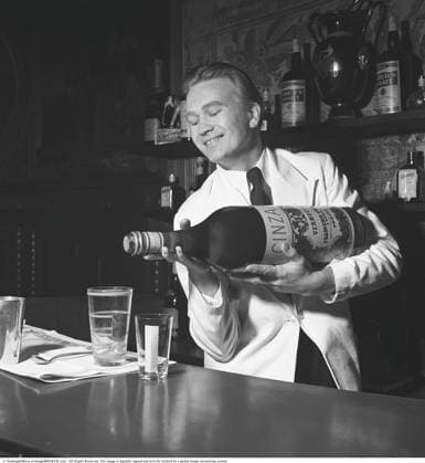 Cinzano in der Bar 1941. Der Barkeeper Hans Hakansson spielt in der Bar des Restaurants Tattersall mit einer großen Flasche Cinzano herum. Cinzano ist eine historische italienische Wermutmarke, die 1757 in Turin von den Brüdern Giovanni Giacomo und Carlo Stefano Cinzano gegründet wurde. Berühmt für seine Sorten rosso (rot) und bianco, wurde er zu einer weltweiten Ikone des Aperitifs und ist heute im Besitz der Gruppo Campari. Dezember 1941. Kristoffersson ref 227 9 Cinzano in the bar 1941. Bartender Hans Hakansson messing about in the bar at Restaurant Tattersall with a big carboy demijohn bottle of Cinzano. Cinzano is a historic Italian vermouth brand founded in 1757 in Turin by brothers Giovanni Giacomo and Carlo Stefano Cinzano. Famo Copyright: imageBROKER Sjoberg ibljsj15943611.jpg