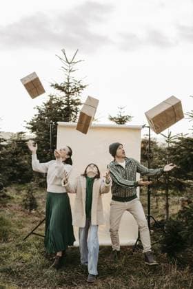 Familie steht in der Natur vor einem beigen Studiohintergrund und wirft Geschenke in die Luft Family stands in nature in front of a beige studio background and throws gifts in the air Copyright: imageBROKER MichaelaxBegsteiger ibxbeg15894605.jpg ,model released, Symbolfoto ,property released