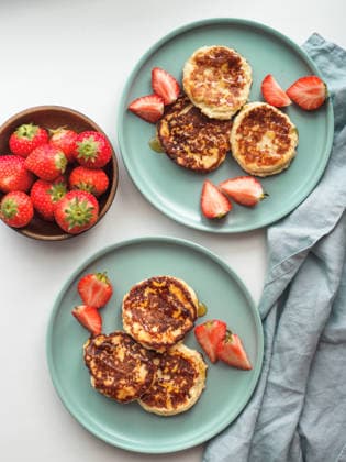 IMAGO Creative, Food, High Protein Frühstück Cottage cheese pancakes, syrniki, ricotta fritters Sweet cheese pancakes on plate served strawberries. Cottage cheese pancakes, syrniki, ricotta fritters, curd fritters. Top view or flat lay. Vertical., 61673528.jpg RECORD DATE NOT STATED
