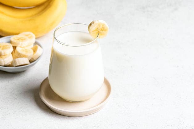 IMAGO Creative, Food, High Protein Frühstück Koreanische Bananenmilch Homemade banana milk. Glass of korean banana milk and banana slices on white background, copy space. (License=RF) Copyright: xZoonar.com OksanaxBratanovax 24387958
