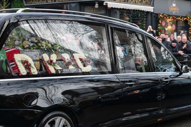 An ˜R Kid™ floral tribute by the casket of Gary Mani Mounfield, Bass Player in the Stone Roses and Primal Scream during the funeral procession through Heaton Moor, Stockport on 22 December 2025. 22 12 2025 Stockport Greater Manchester England Heaton Moor  Copyright: xMattxWilkinsonx