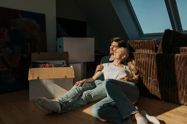 Sunlight shining on young woman spending leisure time with boyfriend while sitting near cardboard boxes in apartment Sweden, Gothenburg, model released, property released Copyright: xMaskotx , MA121959 MA121959