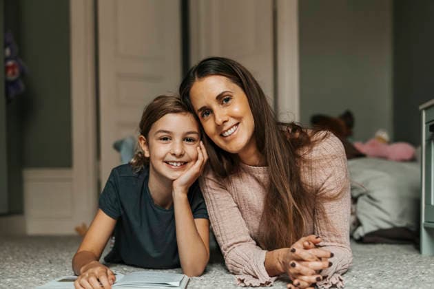 Portrait of smiling mother and daughter lying on carpet at home Sweden, Stockholm, model released, property released Copyright: xMaskotx , MA122117 MA122117