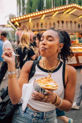Carefree woman eating french fries while enjoying at street party Sweden, Stockholm, model released, property released Copyright: xMaskotx , MA122675 MA122675