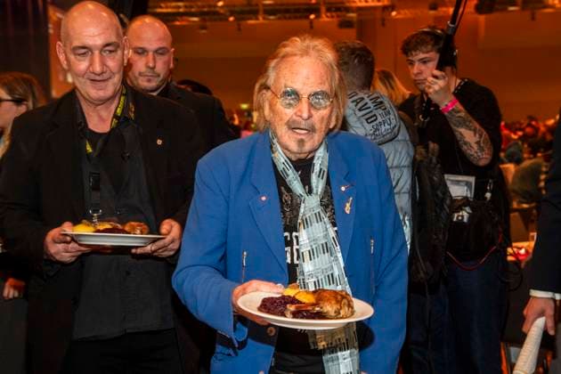 abb: Frank Zander als Promi Kellner beim Servieren von Teller mit Gaensekeuele Rotkohl und Kloesse bei der 31. Frank Zander Weihnachtsfeier Weihnachtsessen fuer Obdachlose und Beduerftige Menschen 2025 im Estrel Convention Center am 22.12.2025 in Berlin Berlin Deutschland