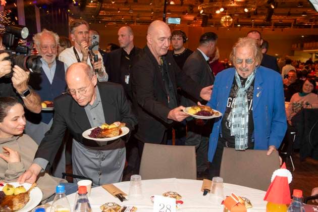 abb: Gregor Gysi und Frank Zander als Promi Kellner beim Servieren von Teller mit Gaensekeuele Rotkohl und Kloesse bei der 31. Frank Zander Weihnachtsfeier Weihnachtsessen fuer Obdachlose und Beduerftige Menschen 2025 im Estrel Convention Center am 22.12.2025 in Berlin Berlin Deutschland