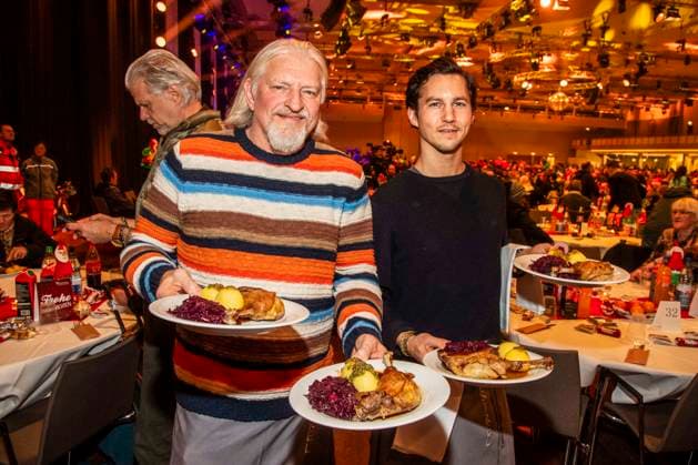 abb: Frank Kessler und Tim Oliver Schultz als Promi Kellner beim Servieren von Teller mit Gaensekeuele Rotkohl und Kloesse bei der 31. Frank Zander Weihnachtsfeier Weihnachtsessen fuer Obdachlose und Beduerftige Menschen 2025 im Estrel Convention Center am 22.12.2025 in Berlin Berlin Deutschland
