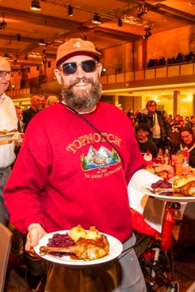 abb: Der Rapper MC Fitti als Promi Kellner beim Servieren von Teller mit Gaensekeuele Rotkohl und Kloesse bei der 31. Frank Zander Weihnachtsfeier Weihnachtsessen fuer Obdachlose und Beduerftige Menschen 2025 im Estrel Convention Center am 22.12.2025 in Berlin Berlin Deutschland