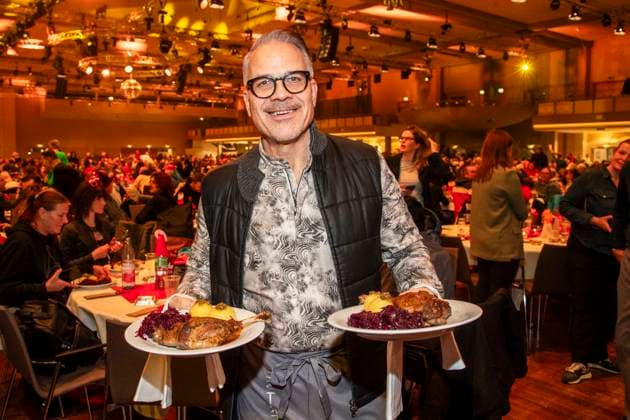 abb: Karsten Speck Schauspieler als Promi Kellner beim Servieren von Teller mit Gaensekeuele Rotkohl und Kloesse bei der 31. Frank Zander Weihnachtsfeier Weihnachtsessen fuer Obdachlose und Beduerftige Menschen 2025 im Estrel Convention Center am 22.12.2025 in Berlin Berlin Deutschland