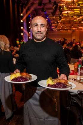 abb: Arthur Abraham ex Boxer als Promi Kellner beim Servieren von Teller mit Gaensekeuele Rotkohl und Kloesse bei der 31. Frank Zander Weihnachtsfeier Weihnachtsessen fuer Obdachlose und Beduerftige Menschen 2025 im Estrel Convention Center am 22.12.2025 in Berlin Berlin Deutschland