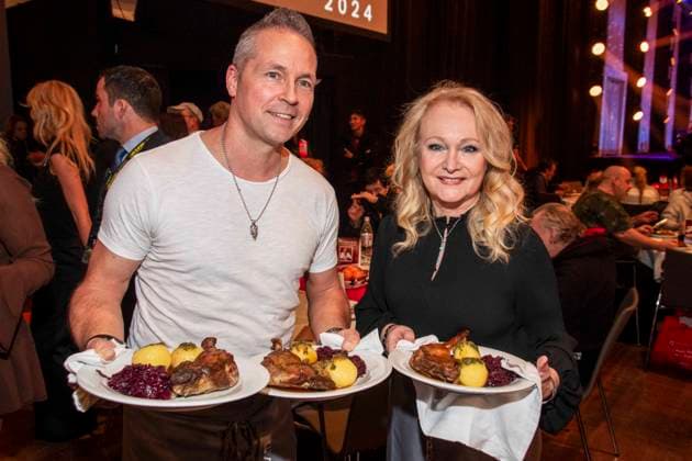 abb: Mitch Keller und Nicole als Promi Kellner beim Servieren von Teller mit Gaensekeuele Rotkohl und Kloesse bei der 31. Frank Zander Weihnachtsfeier Weihnachtsessen fuer Obdachlose und Beduerftige Menschen 2025 im Estrel Convention Center am 22.12.2025 in Berlin Berlin Deutschland
