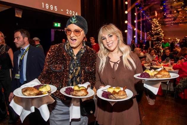 abb: Julian F. M. Stoeckel und Annemarie Eilfeld als Promi Kellner beim Servieren von Teller mit Gaensekeuele Rotkohl und Kloesse bei der 31. Frank Zander Weihnachtsfeier Weihnachtsessen fuer Obdachlose und Beduerftige Menschen 2025 im Estrel Convention Center am 22.12.2025 in Berlin Berlin Deutschland
