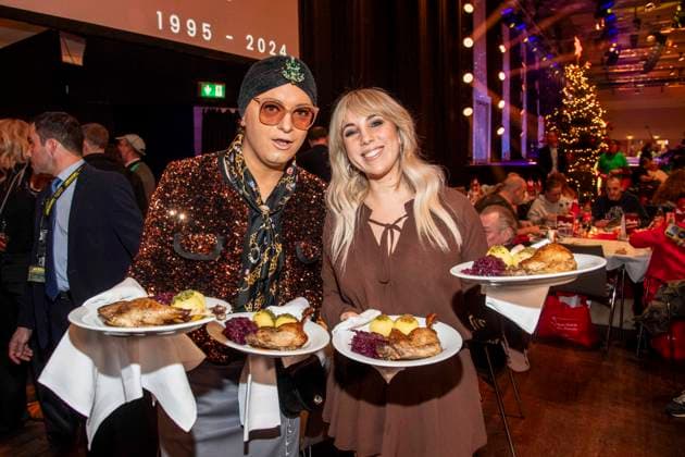 abb: Julian F. M. Stoeckel und Annemarie Eilfeld als Promi Kellner beim Servieren von Teller mit Gaensekeuele Rotkohl und Kloesse bei der 31. Frank Zander Weihnachtsfeier Weihnachtsessen fuer Obdachlose und Beduerftige Menschen 2025 im Estrel Convention Center am 22.12.2025 in Berlin Berlin Deutschland