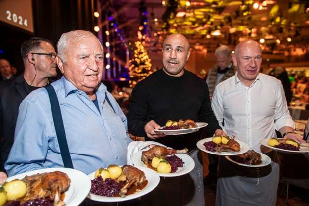 abb: Trainer Georg Bramowski und Ulli Wegner, Arthur Abraham Boxer und Kai Wegner als Promi Kellner beim Servieren von Teller mit Gaensekeuele Rotkohl und Kloesse bei der 31. Frank Zander Weihnachtsfeier Weihnachtsessen fuer Obdachlose und Beduerftige Menschen 2025 im Estrel Convention Center am 22.12.2025 in Berlin Berlin Deutschland