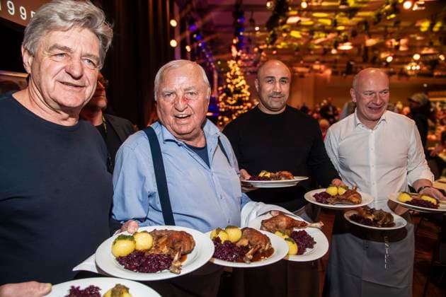 abb: Trainer Georg Bramowski und Ulli Wegner, Arthur Abraham Boxer und Kai Wegner als Promi Kellner beim Servieren von Teller mit Gaensekeuele Rotkohl und Kloesse bei der 31. Frank Zander Weihnachtsfeier Weihnachtsessen fuer Obdachlose und Beduerftige Menschen 2025 im Estrel Convention Center am 22.12.2025 in Berlin Berlin Deutschland
