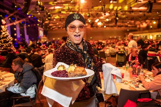 abb: Julian F. M. Stoeckel als Promi Kellner beim Servieren von Teller mit Gaensekeuele Rotkohl und Kloesse bei der 31. Frank Zander Weihnachtsfeier Weihnachtsessen fuer Obdachlose und Beduerftige Menschen 2025 im Estrel Convention Center am 22.12.2025 in Berlin Berlin Deutschland