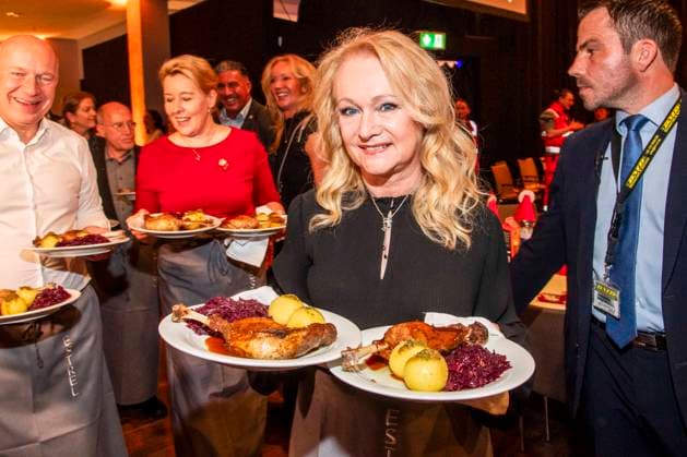 abb: Kai Wegner, Franziska Giffey und Nicole als Promi Kellner beim Servieren von Teller mit Gaensekeuele Rotkohl und Kloesse bei der 31. Frank Zander Weihnachtsfeier Weihnachtsessen fuer Obdachlose und Beduerftige Menschen 2025 im Estrel Convention Center am 22.12.2025 in Berlin Berlin Deutschland