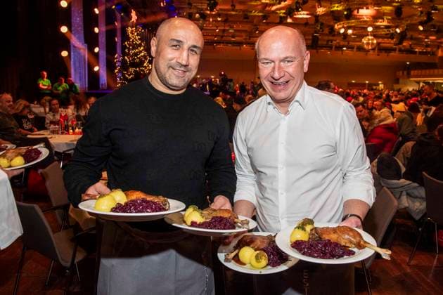 abb: Arthur Abraham und Kai Wegner Boxer als Promi Kellner beim Servieren von Teller mit Gaensekeuele Rotkohl und Kloesse bei der 31. Frank Zander Weihnachtsfeier Weihnachtsessen fuer Obdachlose und Beduerftige Menschen 2025 im Estrel Convention Center am 22.12.2025 in Berlin Berlin Deutschland