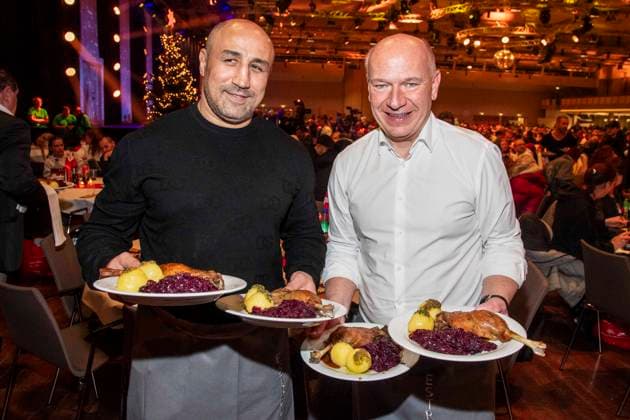 abb: Arthur Abraham und Kai Wegner Boxer als Promi Kellner beim Servieren von Teller mit Gaensekeuele Rotkohl und Kloesse bei der 31. Frank Zander Weihnachtsfeier Weihnachtsessen fuer Obdachlose und Beduerftige Menschen 2025 im Estrel Convention Center am 22.12.2025 in Berlin Berlin Deutschland