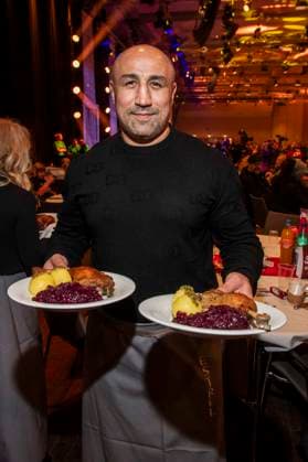 abb: Arthur Abraham ex Boxer als Promi Kellner beim Servieren von Teller mit Gaensekeuele Rotkohl und Kloesse bei der 31. Frank Zander Weihnachtsfeier Weihnachtsessen fuer Obdachlose und Beduerftige Menschen 2025 im Estrel Convention Center am 22.12.2025 in Berlin Berlin Deutschland
