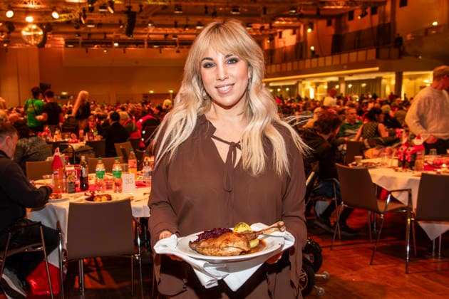 abb: Annemarie Eilfeld Saengerin als Promi Kellner beim Servieren von Teller mit Gaensekeuele Rotkohl und Kloesse bei der 31. Frank Zander Weihnachtsfeier Weihnachtsessen fuer Obdachlose und Beduerftige Menschen 2025 im Estrel Convention Center am 22.12.2025 in Berlin Berlin Deutschland
