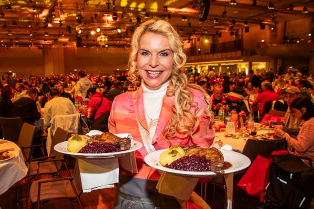 abb: Victoria Herrmann Moderatorin als Promi Kellner beim Servieren von Teller mit Gaensekeuele Rotkohl und Kloesse bei der 31. Frank Zander Weihnachtsfeier Weihnachtsessen fuer Obdachlose und Beduerftige Menschen 2025 im Estrel Convention Center am 22.12.2025 in Berlin Berlin Deutschland