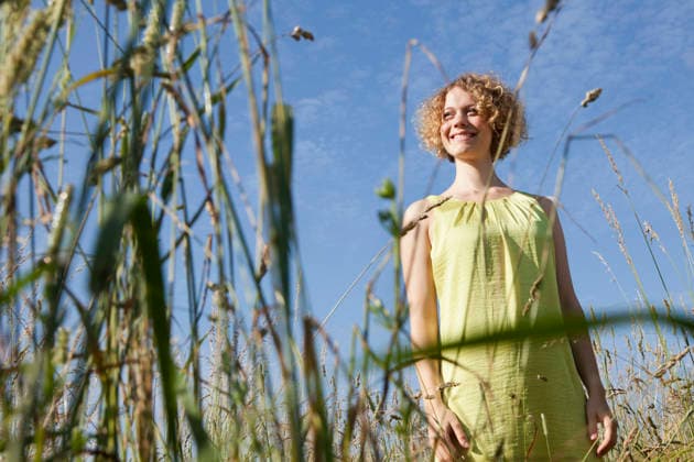 Smiling person in summer dress standing in tall grass outdoors in Munich model released, Symbolfoto, LDF000853