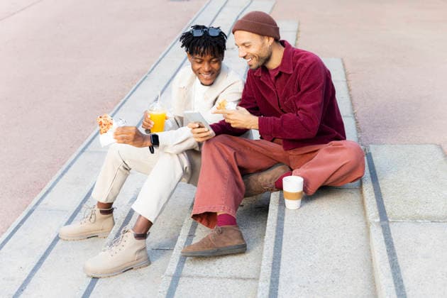 Friends sharing a relaxed lunch and conversation on city steps model released, Symbolfoto, PCLF02990