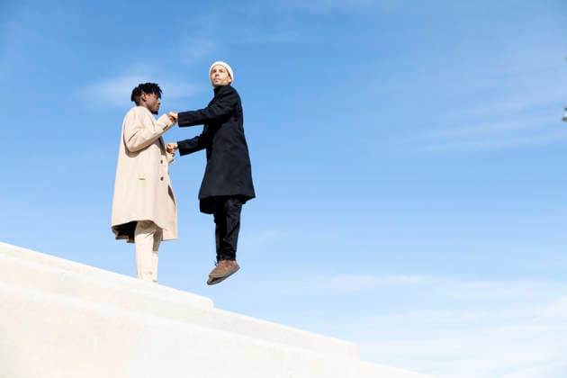 Two people collaborating and reaching hands on outdoor geometric stairs model released, Symbolfoto, PCLF03052
