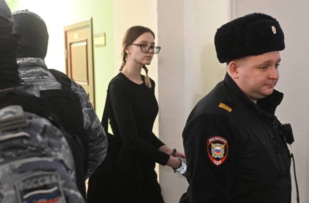 Russia Terrorist Organisation Participant Trial 9079025 24.12.2025 Student at the State University of Education Polina Kostikova, charged with participating in a terrorist organisation, is escorted by police before a hearing at the 2nd Western Military District Court in Moscow, Russia. According to investigators, while in Turkey in 2022, Kostikova joined the Ukrainian Army s Azov Battalion (designated terrorist and banned in Russia) and later began assisting the Russian Volunteer Corps with recruitment and fundraising. Mikhail Voskresenskiy Sputnik Moscow Russia  Copyright: xMikhailxVoskresenskiyx