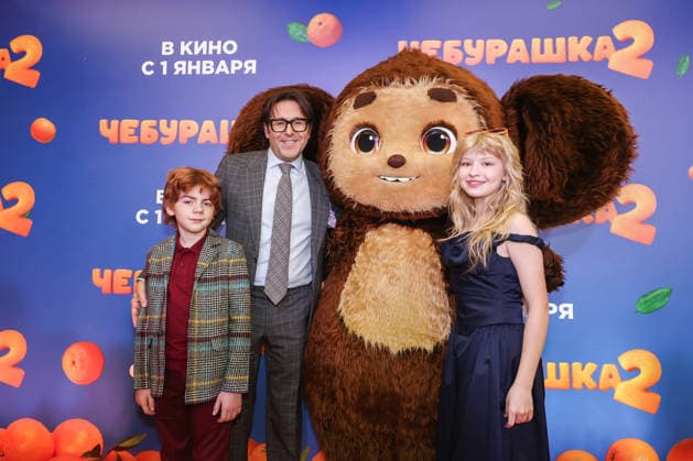 RUSSIA, MOSCOW - DECEMBER 24, 2025: Actor Ilya Kondratenko, TV host Andrei Malakhov (L-R) and actress Yeva Smirnova pose with an artist cosplaying the title character on the red carpet during the premiere of the family comedy Cheburashka 2 by Dmitry Dyachenko at the KARO 11 Oktyabr cinema on Novy Arbat Street (New Arbat Avenue). Valery Sharifulin TASS  86691917
