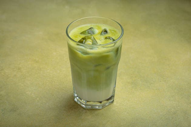 Iced matcha latte resting on a green background table in a glass Refreshing iced matcha latte, combining the earthy notes of matcha with the creamy texture of milk, served in a clear glass on a green surface, 63100542.jpg RECORD DATE NOT STATED