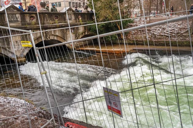 Die provisorische Rampe an der Eisbachwelle wurde heute früh von der Feuerwehr entfernt, jetzt ist die Eisbachwelle erneut verschwunden, die Zuschauer sind traurig, München, 28. Dezember 2025 Deutschland, München, 28. Dezember 2025, die Feuerwehr hat vor zwei Stunden am Sonntagmorgen um 9 Uhr die provisorische Rampe an der Eisbachwelle wieder entfernt, die Eisbachwelle ist wieder flach, nur unsurfbares Weißwasser schäumt, drei Tage nachdem die berühmte Surfwelle an Weihnachten mit einem provisorischen Brett erst wieder surfbar gemacht worden war, am Ufer und auf der Brücke bleiben heute am Sonntagmittag viele Münchner und Touristen stehen, schauen traurig auf die erneut verschwundene Welle im Eisbach, teilweise Absperrgitter am Bach