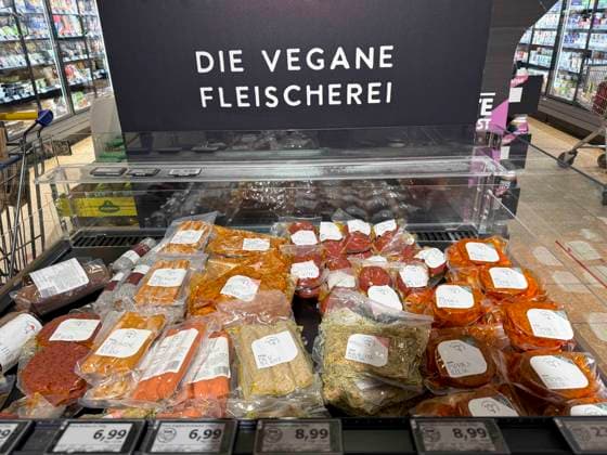 abb: Kuehlregal mit verschiedenen Sorten Wurst Steak Bratlinge Veganes Fleischprodukte Hinweisschild Aufschrift Die Vegane Fleischerei im Supermarkt bei Edeka -Vegetarisches Fleisch, Fleischersatz sind Produkte, die tierisches Fleisch ersetzen und auf Basis pflanzlicher Proteine wie Soja (Tofu, Sojagranulat), Weizen (Seitan) oder Erbsen hergestellt werden Hh Deutschland *** abb Kuehlregal with different types of sausage Steak Bratlinge Vegan meat products Sign with the inscription Die Vegane Fleischerei in the supermarket at Edeka Vegetarian meat, meat substitutes are products that replace animal meat and are made on the basis of vegetable proteins such as soy tofu, soy granules, wheat seitan or peas Hh Germany