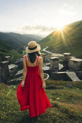 Reisende, hübsche Frau im roten Maxisommerkleid, genießt den Wellness Lifestyle bei Sonnenuntergang in den Bergen in Ushguli, Georgia, mit malerischer Tallandschaft Traveler pretty woman in red maxi sundress enjoying mountain sunset wellness lifestyle in Ushguli Georgia with scenic valley landscape Copyright: imageBROKER EvaldasxMikoliunas ibxemi15189298.jpg ,model released, Symbolfoto ,property released