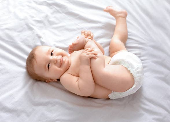Beautiful caucasian baby laying on bed, playing with feet Beautiful caucasian baby laying on bed, playing with feet and smiling at camera, top view, copy space. Adorable toddler in diaper having fun alone, lying on white, laughing. Toddler, baby, infant, model released, , 97848772.jpg RECORD DATE NOT STATED