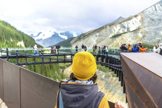 Ein Tourist mit gelber Mütze steht auf einer Aussichtsplattform und bewundert die atemberaubende Aussicht auf den Athabasca Gletscher und die umliegenden Berge im Jaspis Nationalpark Tourist wearing a yellow beanie stands on a viewing platform, admiring the stunning view of athabasca glacier and the surrounding mountains in jasper national park Copyright: imageBROKER UnaixHuizi ibxuhu16041390.jpg ,model released, Symbolfoto ,property released