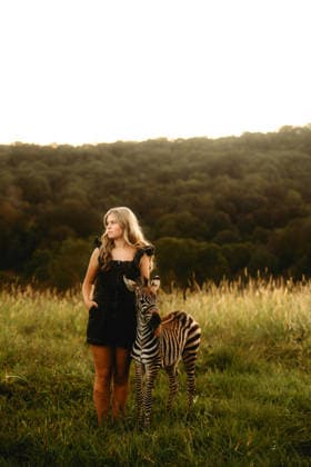 girl standing in a field with a baby zebra Beaver, West Virginia, United States CR_ZVBJ251230-1924945-01 ,model released, Symbolfoto