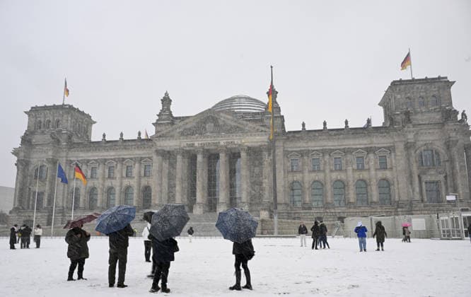 Snowfall in Berlin, Germany BERLIN, GERMANY - DECEMBER 31: People walk in front of Reichstag Palace as the city center blanketed in white after heavy snowfall in Berlin, the capital of Germany on December 31, 2025. Halil Sagirkaya Anadolu Berlin Germany. Editorial use only. Please get in touch for any other usage.  Copyright: x2025xAnadoluxHalilxSagirkayax